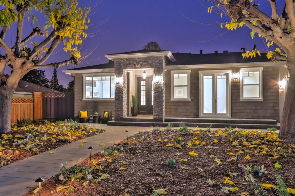 Saratoga front view at night, with soft lighting casting a welcoming glow on the front door and surrounding yard.